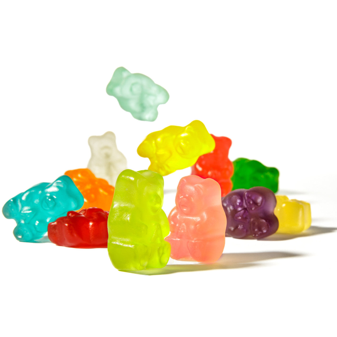 Colorful translucent Albanese gummy bears in green, yellow, red, orange, blue, purple pile