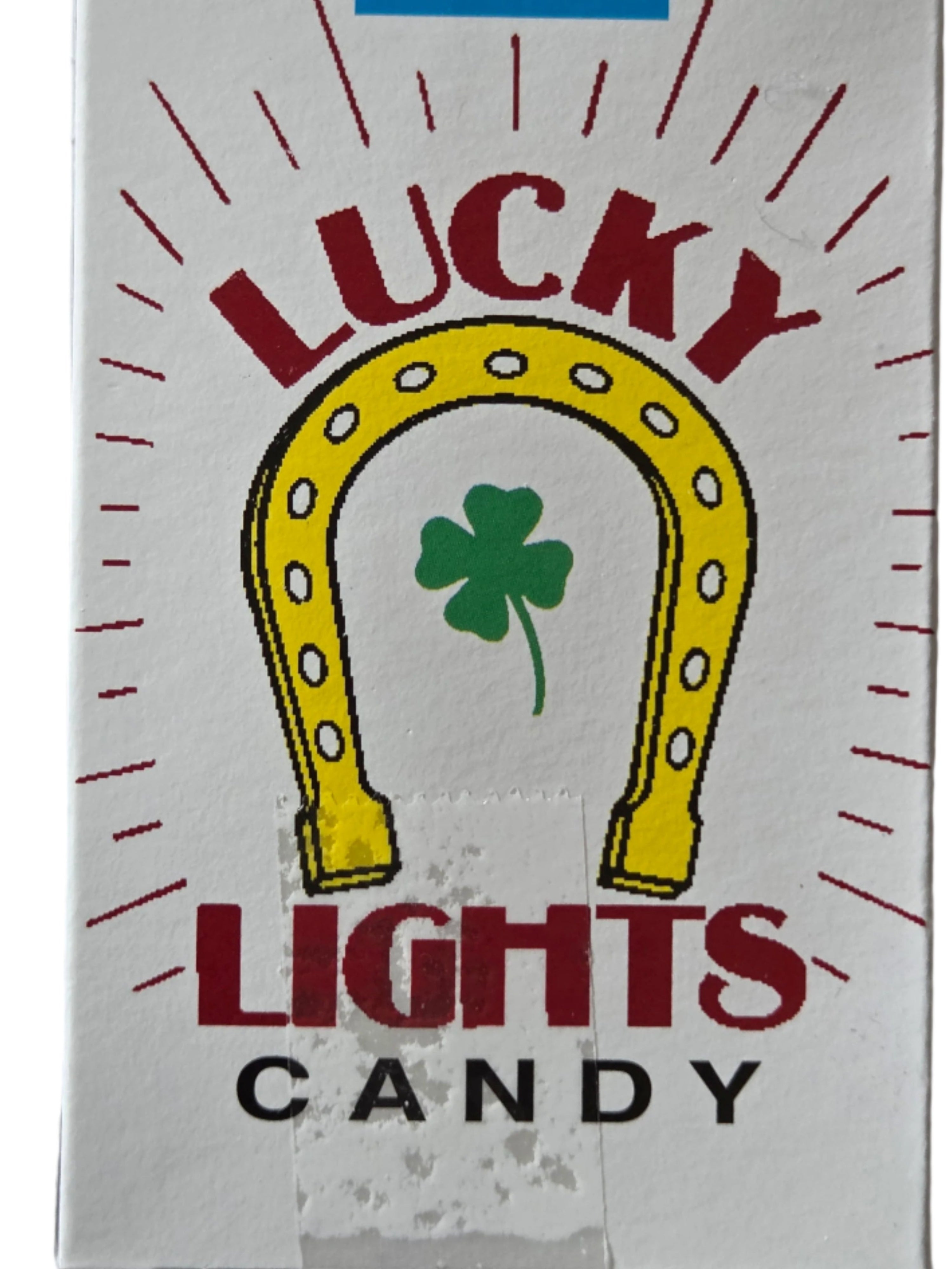 White Lucky Lights candy cigarettes box with yellow horseshoe, green shamrock, red lettering
