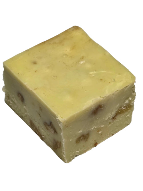 Square pale yellow pistachio fudge with embedded chopped nuts