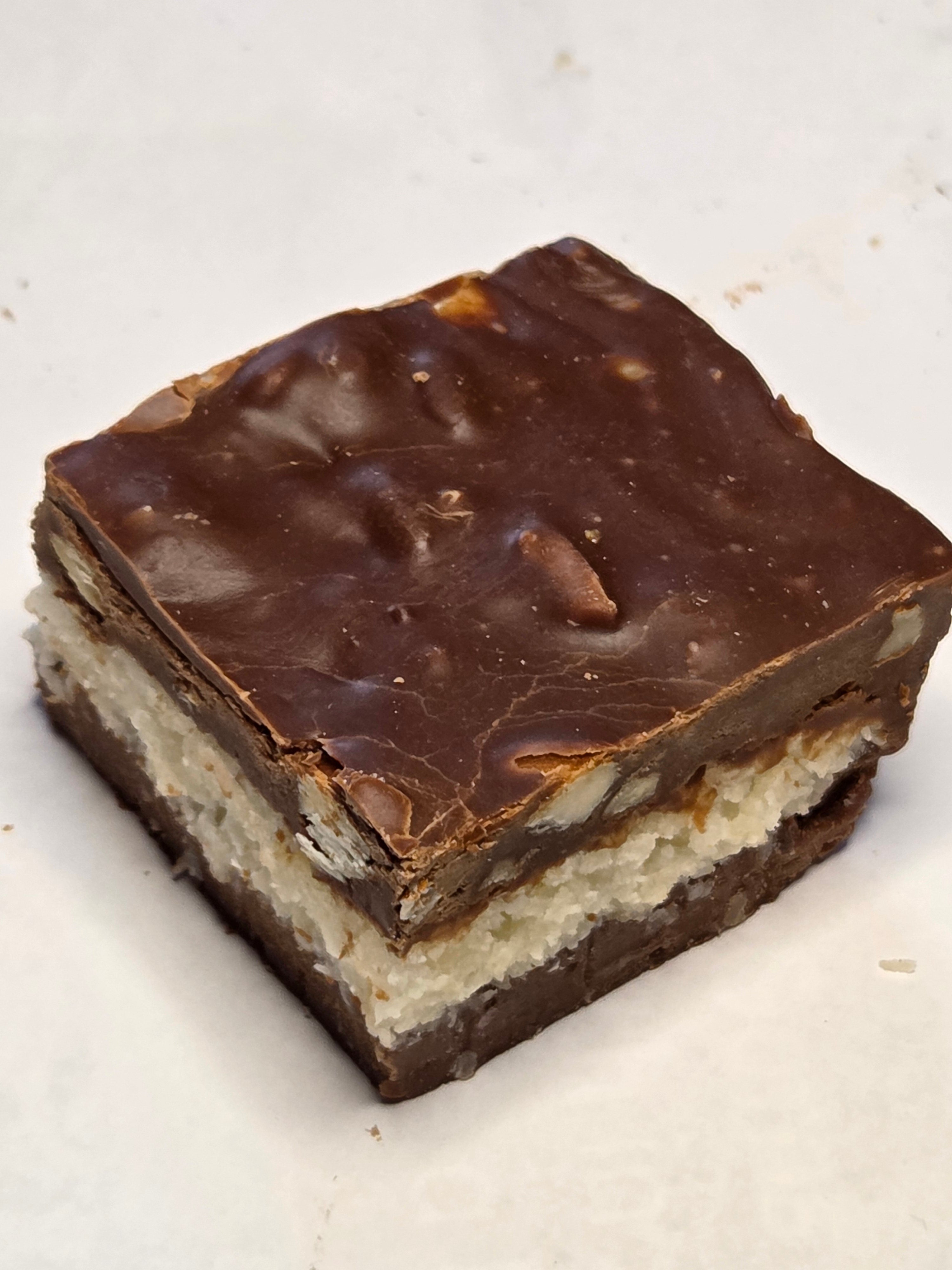 Square Coconut Almond Chocolate Fudge bar with glossy dark brown top and creamy white interior
