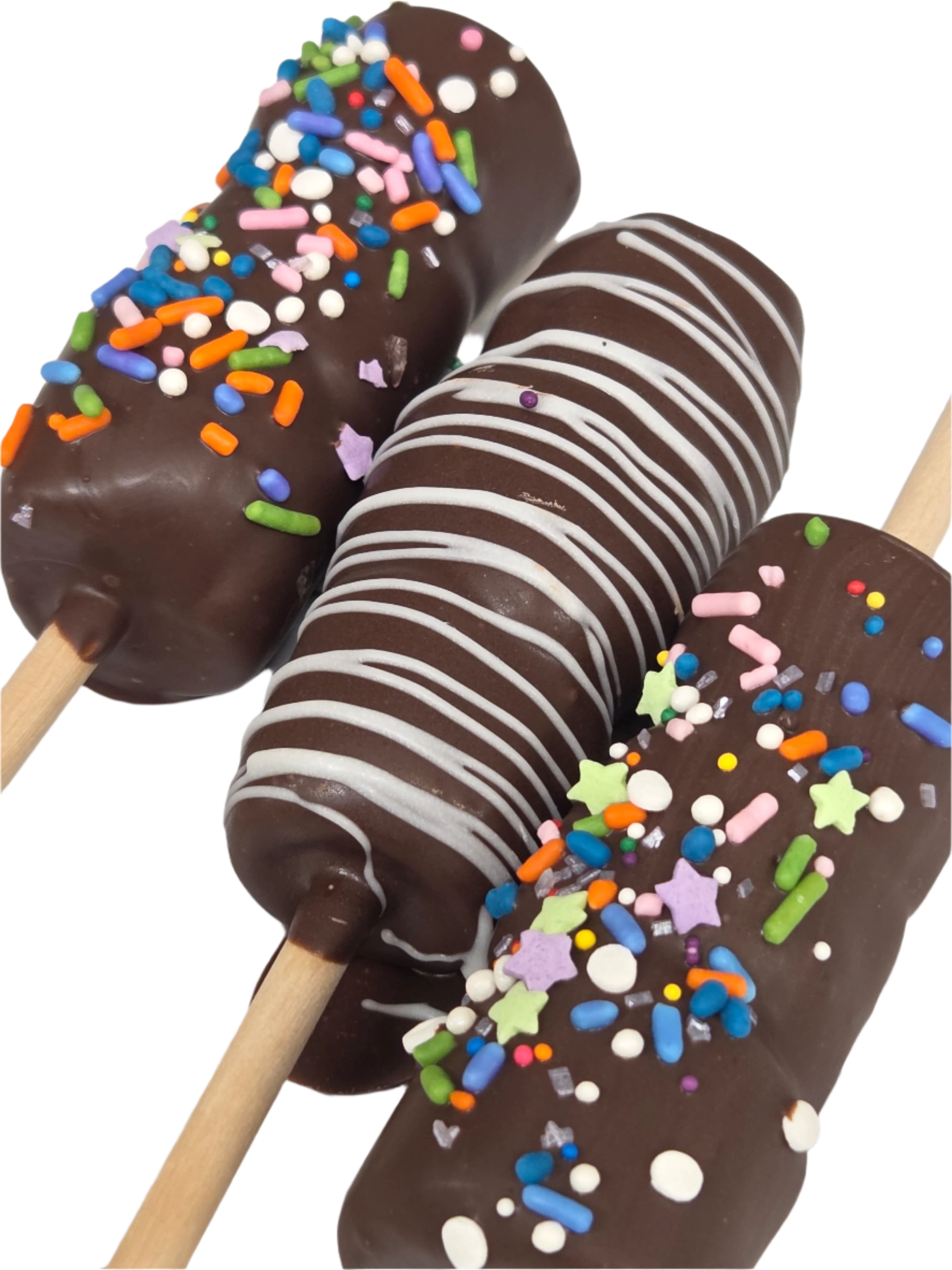 Three chocolate-covered corn dogs on sticks with sprinkles and M&M’s drizzle