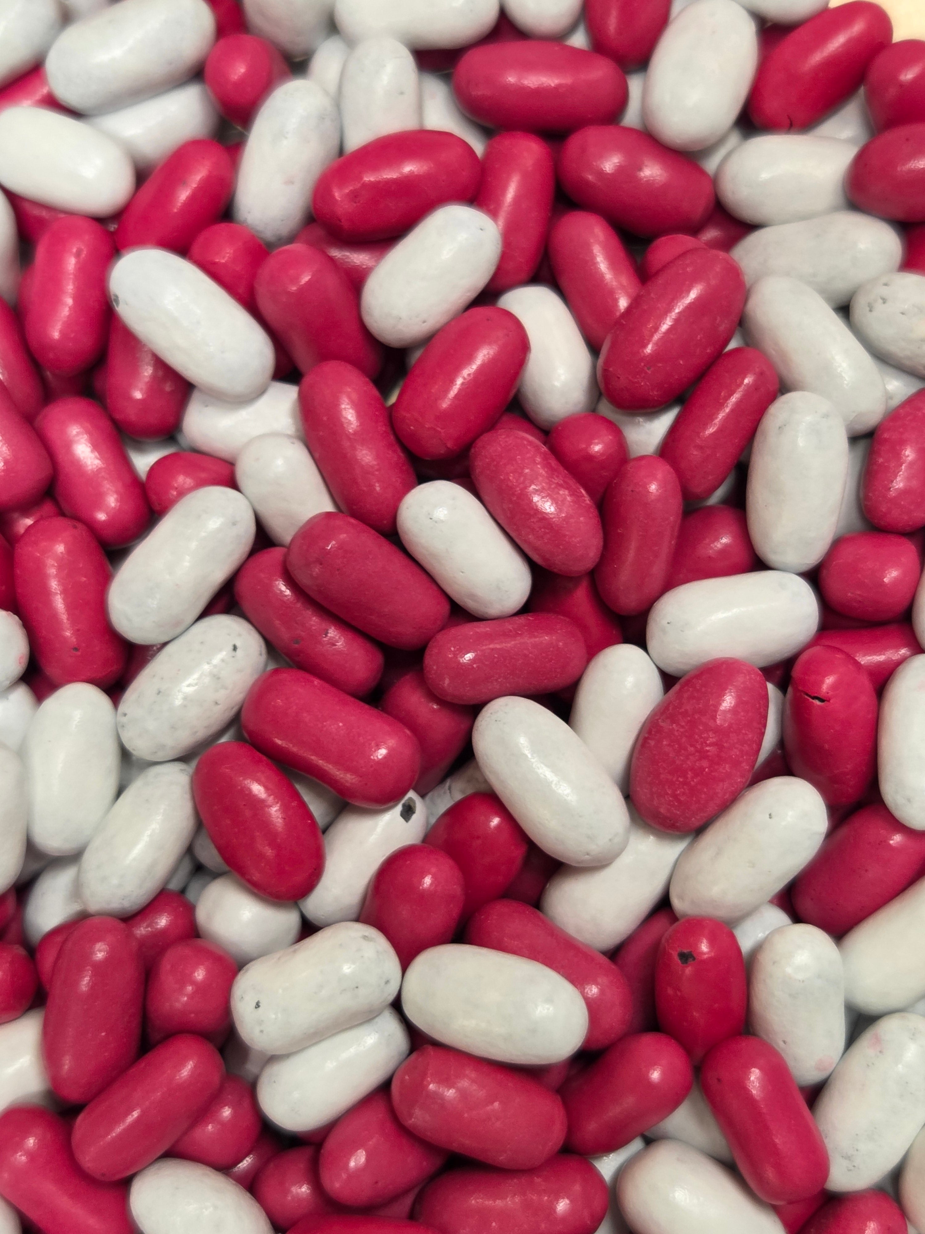 Pile of glossy red and matte white Good & Plenty candies