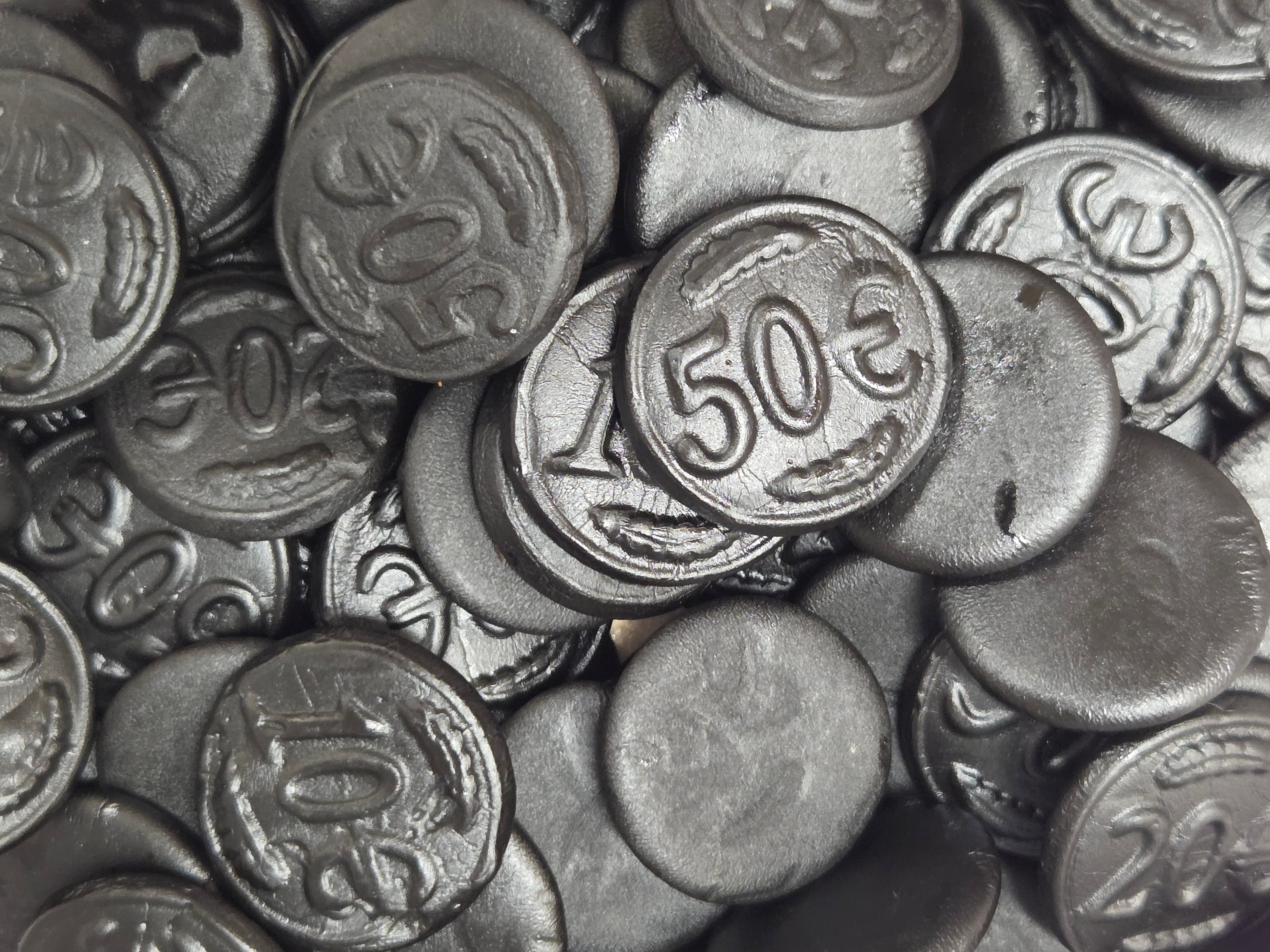 Black glossy licorice coins with embossed euro denominations