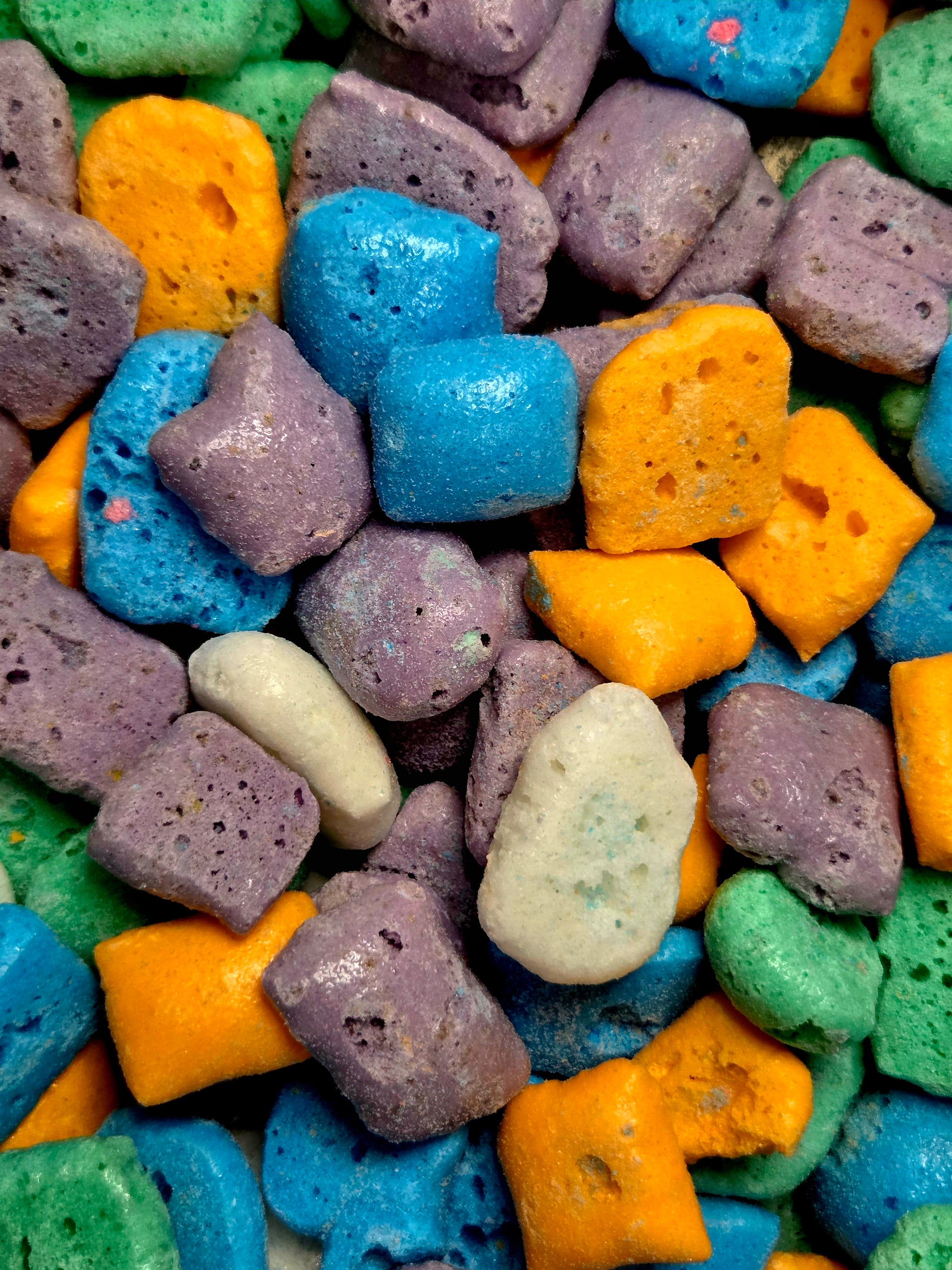 Colorful porous foam pieces in blue, orange, purple, green, and beige from Crazy Bites Laffy Taffy 3oz