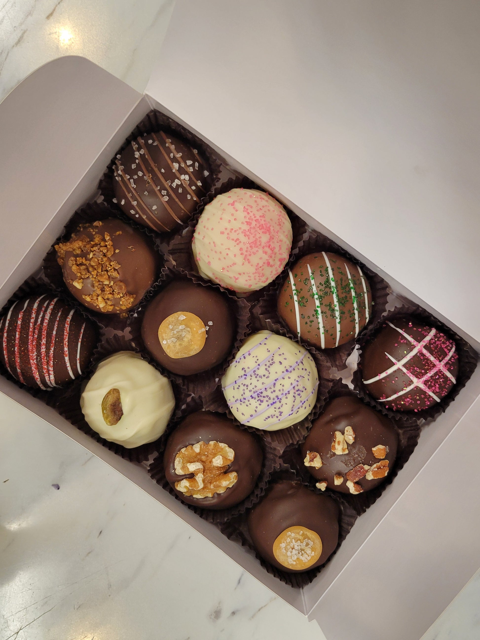 Truffle 12PK: Assorted glossy chocolate truffles with nuts, gold leaf