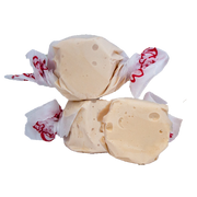 Cream-colored glossy Taffy Honey candies wrapped in white paper with red cursive lettering