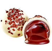 White Russian Truffle split open, creamy white shell with glossy dark chocolate center and cocoa nibs