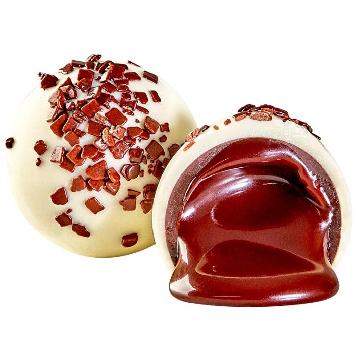 White Russian Truffle split open, creamy white shell with glossy dark chocolate center and cocoa nibs