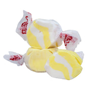 Yellow and white swirled taffy candies in Taffy Butter Popcorn, wrapped in clear cellophane with red logos
