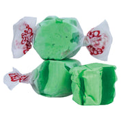 Green apple taffy candies, glossy green wrapped in white paper with red branding