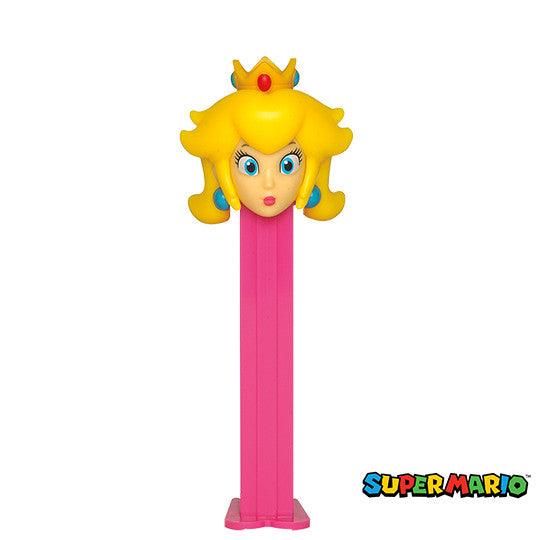 Pink PEZ Nintendo Princess Peach dispenser with yellow hair, blue eyes, turquoise earrings, and gold crown with red jewels