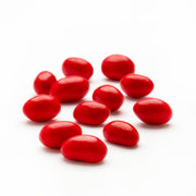 Bright red glossy Boston Baked Beans jelly beans on white surface