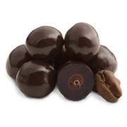 Glossy dark chocolate coated espresso beans, one sliced to reveal inner seed